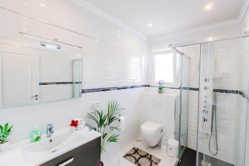 Un baño blanco con ducha y WC. en Villa HAYAHAY with PRIVATE POOL & Amazing view, en Calpe