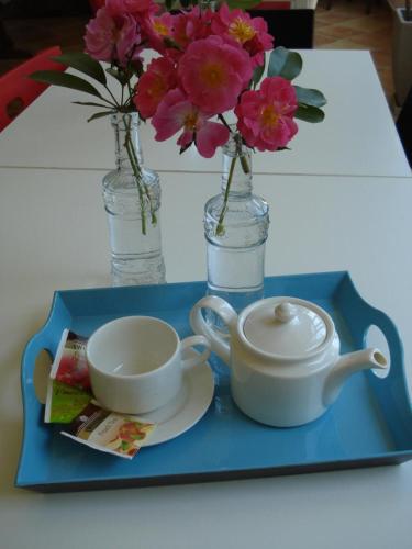 a blue tray with a cup and a teapot and flowers at Breezes B&B in Conca Specchiulla