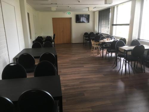 a room with tables and chairs in a classroom at Hotelli Salpa in Luumäki