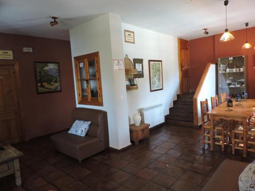 a living room with a couch and a table and stairs at Casa Rural Los Parrales in El Tranco