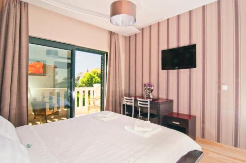 a bedroom with a white bed and a balcony at Apartments Grifone Lux in Herceg-Novi