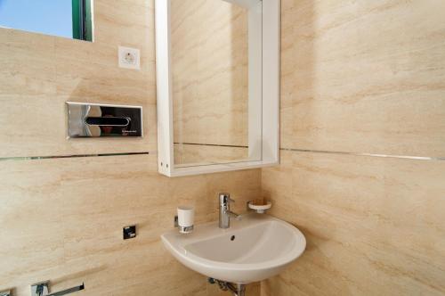 a bathroom with a sink and a mirror at Apartments Grifone Lux in Herceg-Novi