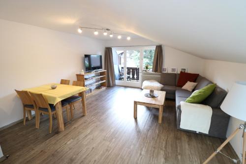 a living room with a couch and a table at Alpen - Apartments in Garmisch-Partenkirchen
