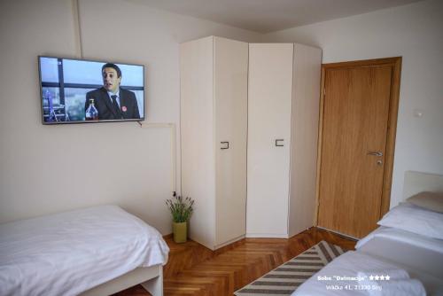 a bedroom with a bed and a tv on the wall at Apartment/Room ''Dalmacija'' SINJ in Sinj