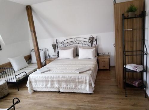 a bedroom with a white bed with a metal headboard at Family Hotel Bellehouse in Chernomorets