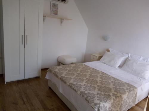 a bedroom with a bed and a white cabinet at Family Hotel Bellehouse in Chernomorets