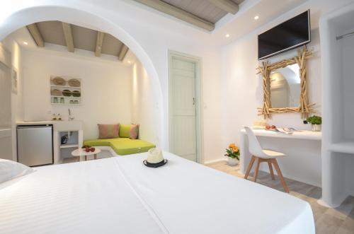 a white bedroom with a white bed and a desk at Naxian Spirit Suites & Apartments in Agia Anna Naxos