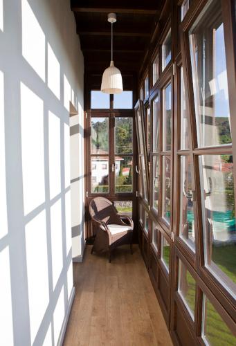 a hallway with a chair in a room with windows at Hotel Villa Marrón in Naves