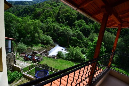 a view of a waterfall from the balcony of a house at Family Hotel Gorski Kut in Rilski Manastir