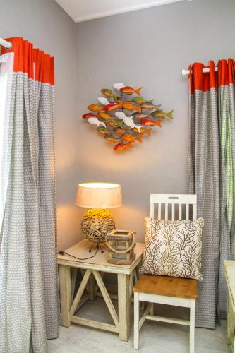 a room with a table with a lamp and a chair at Antigua Village Beach Resort in Saint Johnʼs