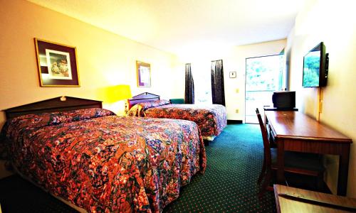 a hotel room with two beds and a desk at American Motel - Lenoir in Lenoir
