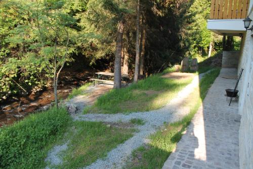 a walkway with a bench on the side of a house at Arnica Montana in Arieşeni