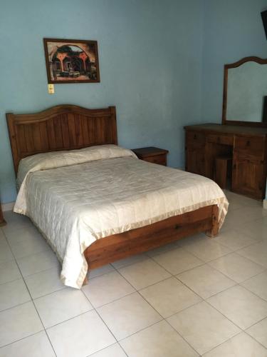 a bedroom with a bed and a mirror on the wall at Hotel Posada Andaluz in Xochitepec