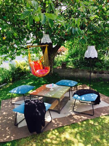 a hammock and a table and chairs under a tree at Chez Sven - Studio 'Le Grand' in Lohn-Ammannsegg