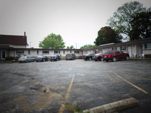 a parking lot with cars parked in front of a building at Canadiana Motel in Hanover