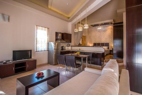 a living room and kitchen with a couch and a table at Bay View in Faliraki
