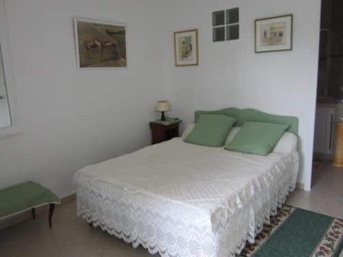 ヴァンスにあるStudio les mursのベッドルーム(緑の枕が付く白いベッド付)
