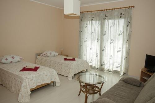 a room with two beds and a table and a couch at Europe Guesthouse in Narva