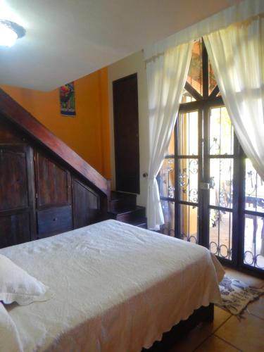 1 dormitorio con cama y ventana grande en Posada Bugambilias, en Catemaco
