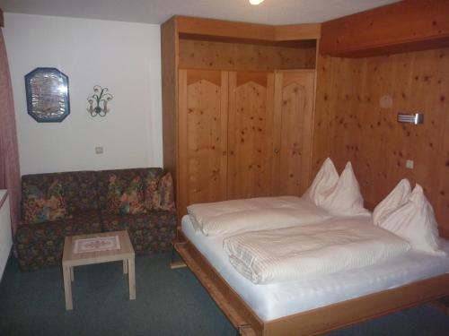 a small bedroom with a bed and a couch at Haus Bellis in Neustift im Stubaital