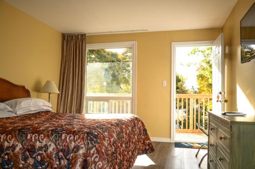 a bedroom with a bed and a balcony at Meaford Inn in Meaford