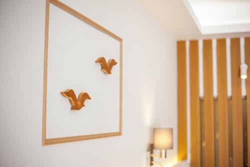 a picture on a wall with two butterflies on it at Alexander Studios & Suites - Adults Only in Faliraki