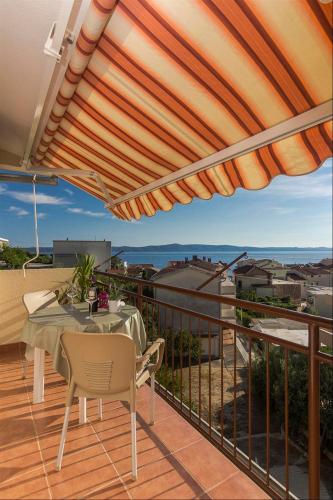 a patio with a table and chairs on a balcony at Apartments Garmaz in Podgora