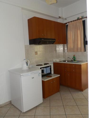 eine Küche mit einem weißen Kühlschrank und einer Spüle in der Unterkunft Nanos Studios in Parga