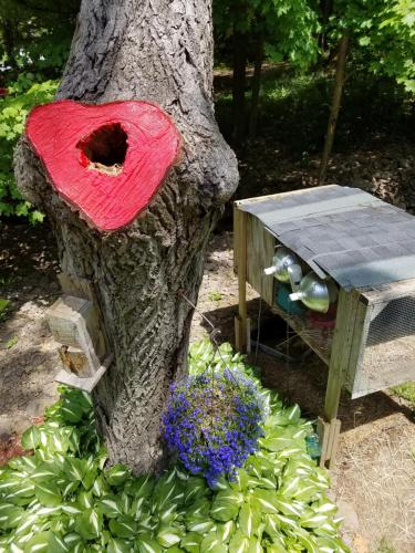 a tree with a red hat on top of a bird house at Kountry Living Bed and Breakfast in Oneonta