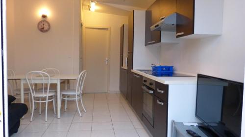 a small kitchen with a table and chairs in a room at Residence des Ondines in Damgan