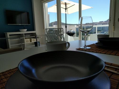 een tafel met een zwarte kom en een glas wijn bij Apartamento Cala Finestrat in Benidorm