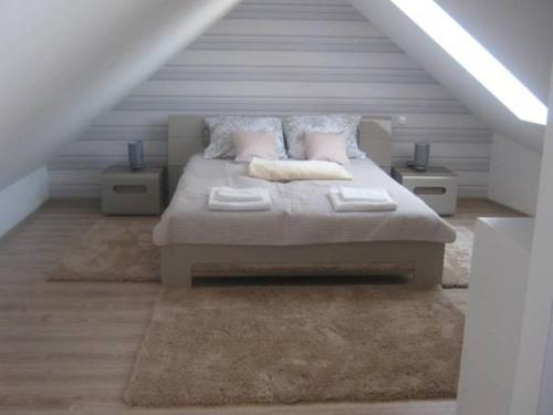 a bedroom with a large bed in a attic at Apartament Monika Rewal z widokiem na morze in Rewal