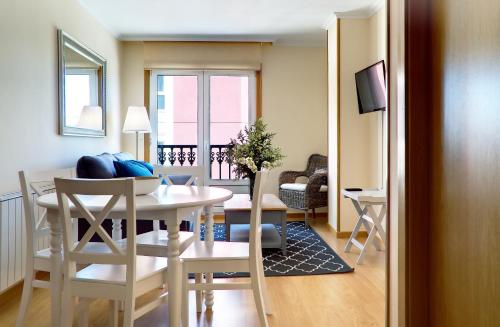 a dining room and living room with a table and chairs at Duerming Sea View Viveiro in Viveiro