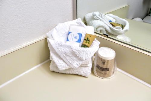 a towel basket sitting on a counter in front of a mirror at Guest House Inn Medical District near Texas Tech Univ in Lubbock