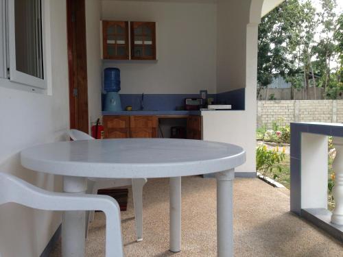 Mangoes Place في موالبوال: طاولة بيضاء وكراسي في مطبخ