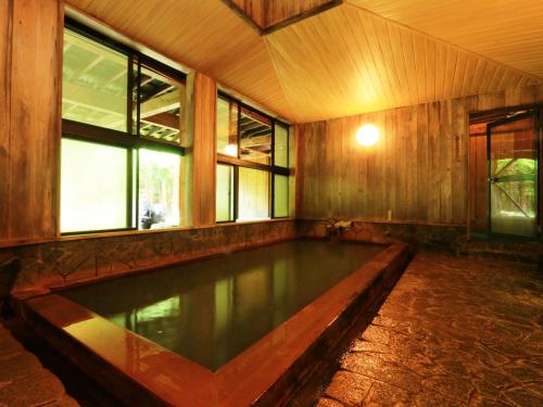 una piscina en una habitación con ventanas en Yunohirakan en Takayama