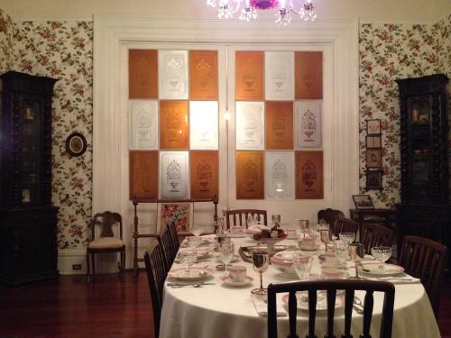 a dining room with a table with a white table cloth at Stone House Musical B&B in Natchez