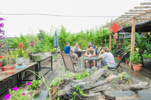 a group of people sitting at tables in a garden at Sky Garden Inn in Guilin