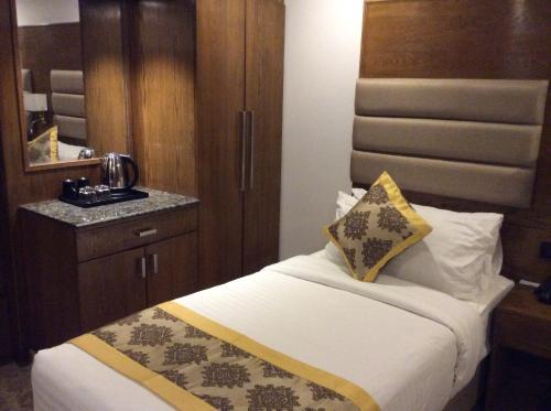 a hotel room with a bed and a mirror at Marino Royal Hotel in Dhaka