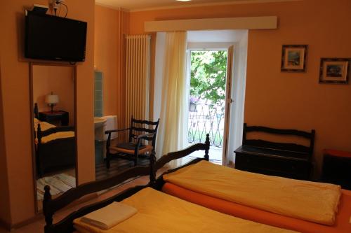 a bedroom with two beds and a television and a window at Osteria Battello in Caslano