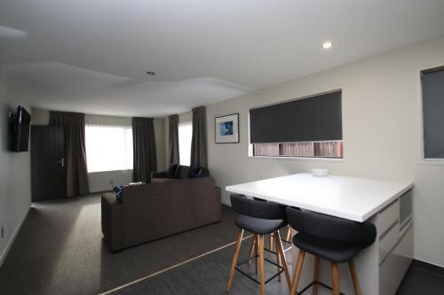a kitchen and living room with a counter and chairs at Dunedin Motel and Villas in Dunedin