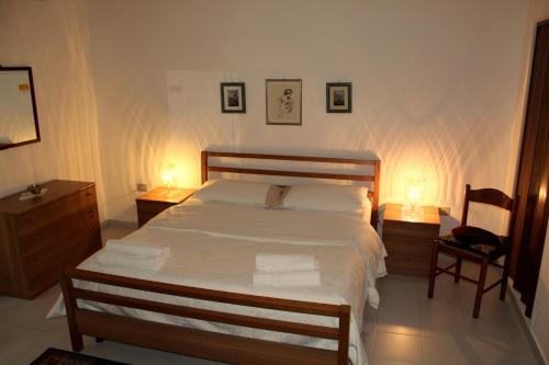um quarto com uma cama com 2 candeeiros e 2 cadeiras em Caricia em Alghero