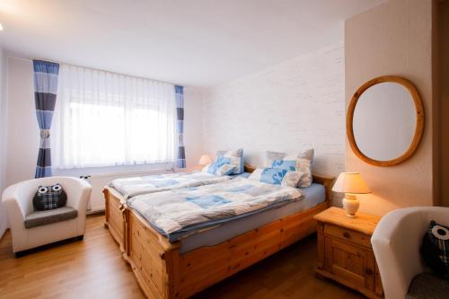 sypialnia z dużym łóżkiem i lustrem w obiekcie Boxis Ferienhaus w mieście Probstzella