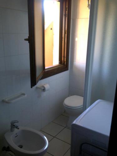 a bathroom with a toilet and a sink and a mirror at panato's home in Torre Dei Corsari