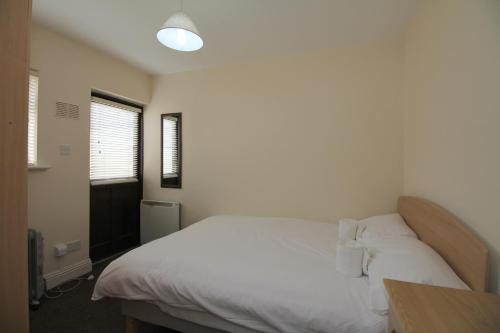 ダブリンにあるStoneybatter Self Catering Apartmentのベッドルーム1室(白いシーツと枕のベッド1台付)