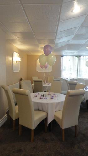 a dining room with a table with balloons and chairs at The Beechfield Hotel in Blackpool