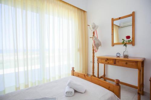 a bedroom with a bed and a mirror and a dresser at Kamiros Apartment in Kalavárda