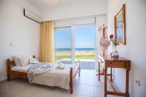 a bedroom with a bed and a view of the ocean at Kamiros Apartment in Kalavárda