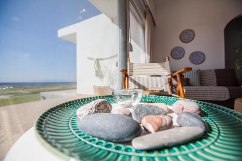 a table with a green plate with rocks on it at Kamiros Apartment in Kalavárda