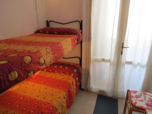 ein kleines Zimmer mit 2 Betten und einem Fenster in der Unterkunft Villetta Cenam 37 in Lido delle Nazioni